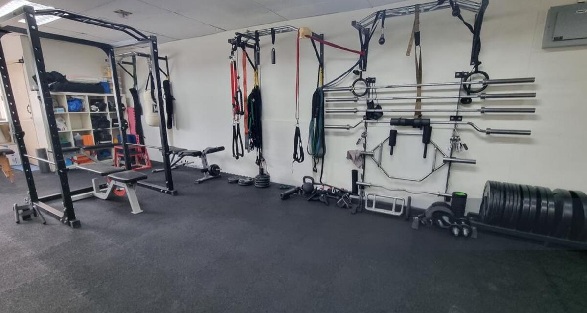 Functional training wall with barbells, bands and cable station